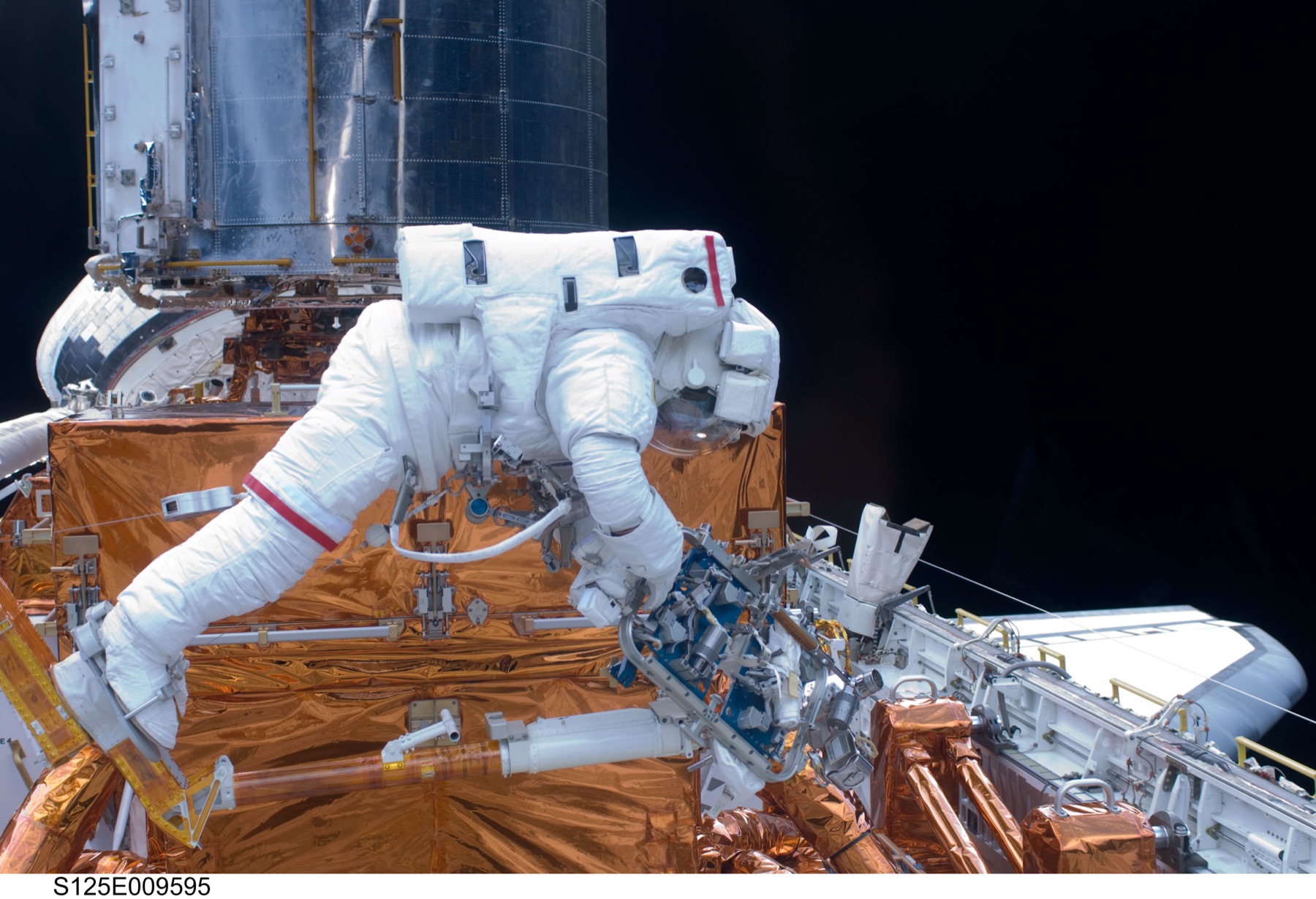 John Grunsfeld, STS-125 görevinde Hubble'ın üzerinde çalışırken. Teleskoba eliyle dokunan son insanlardan biri.